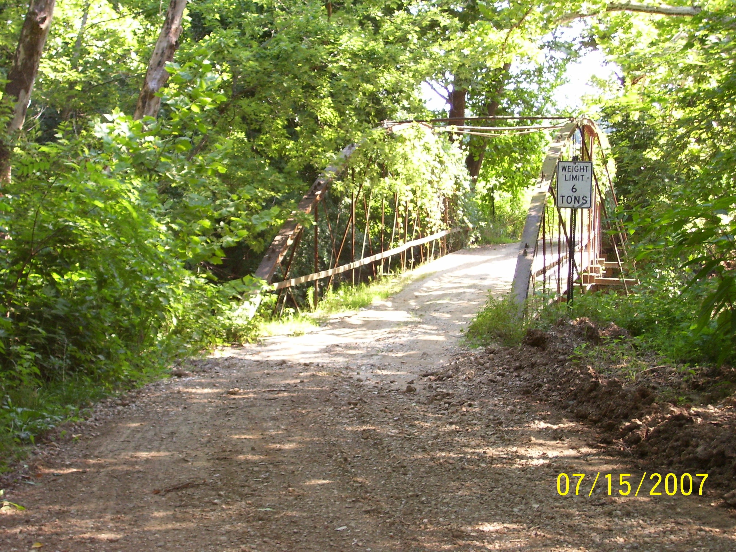 Dirt path leading to a forest bridge