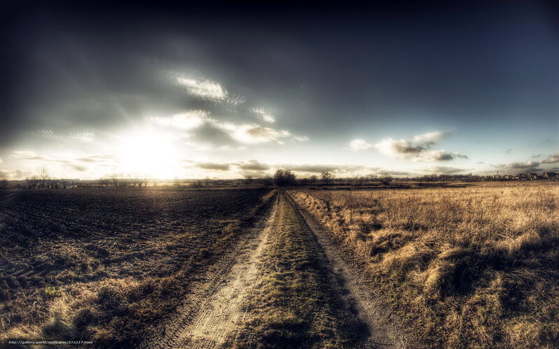 Dirt path through fields at sunset