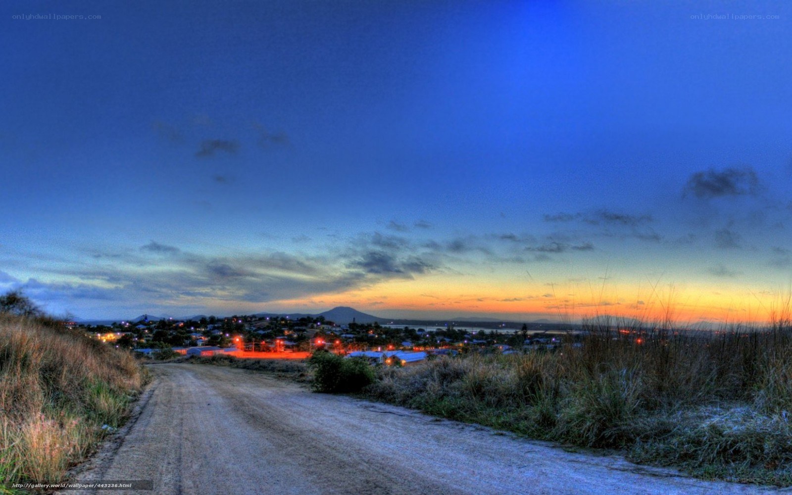 Dirt road at dusk overlooking town