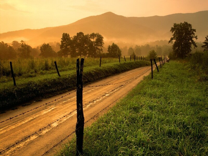 Dirt road at sunrise with mountains