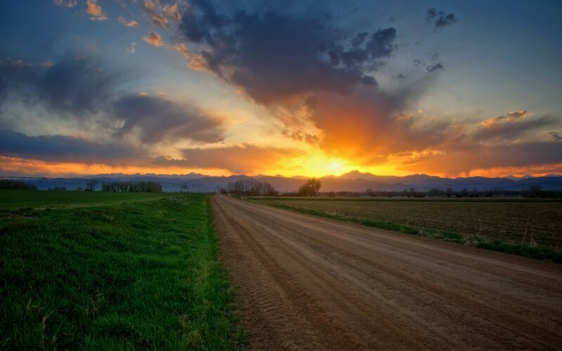 Dirt road at sunset with mountains