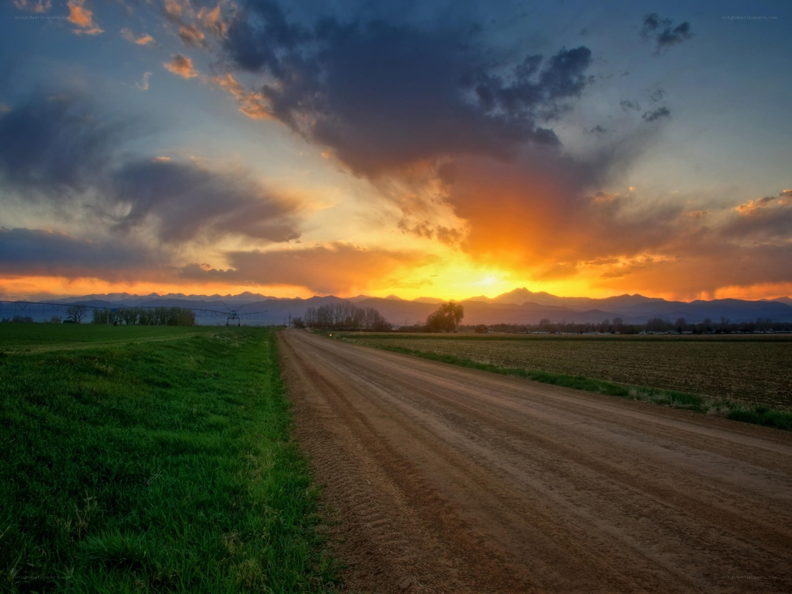 Dirt road at sunset with mountains