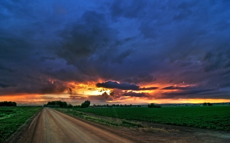 Dirt road at sunset with stormy sky