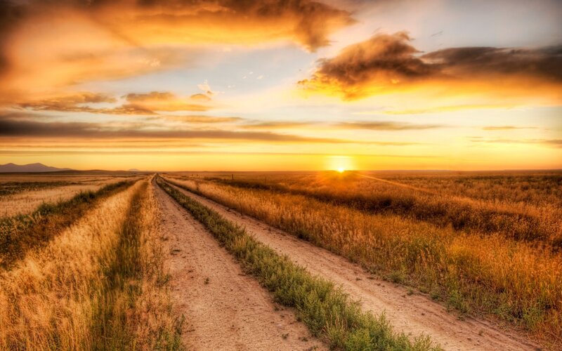 Dirt Road in Field — Orange, Serene, Sunset, Photograph, Sun, Clouds, Mountains