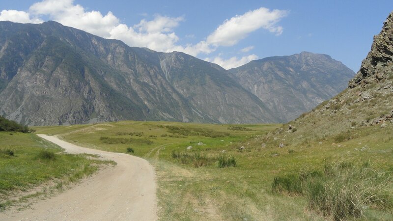 Dirt Road in Mountain Valley — Green, Serene, Afternoon, Photograph, Mountains, Grassland