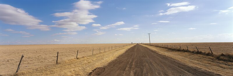 Dirt road through a dry field
