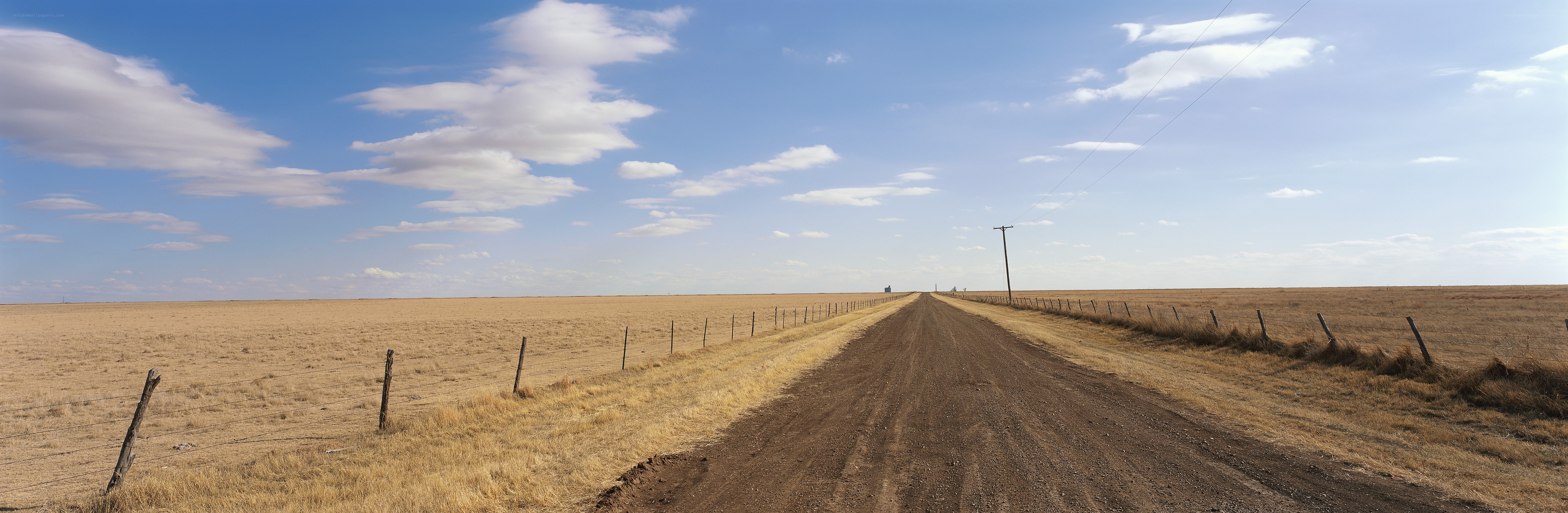 Dirt road through a dry field