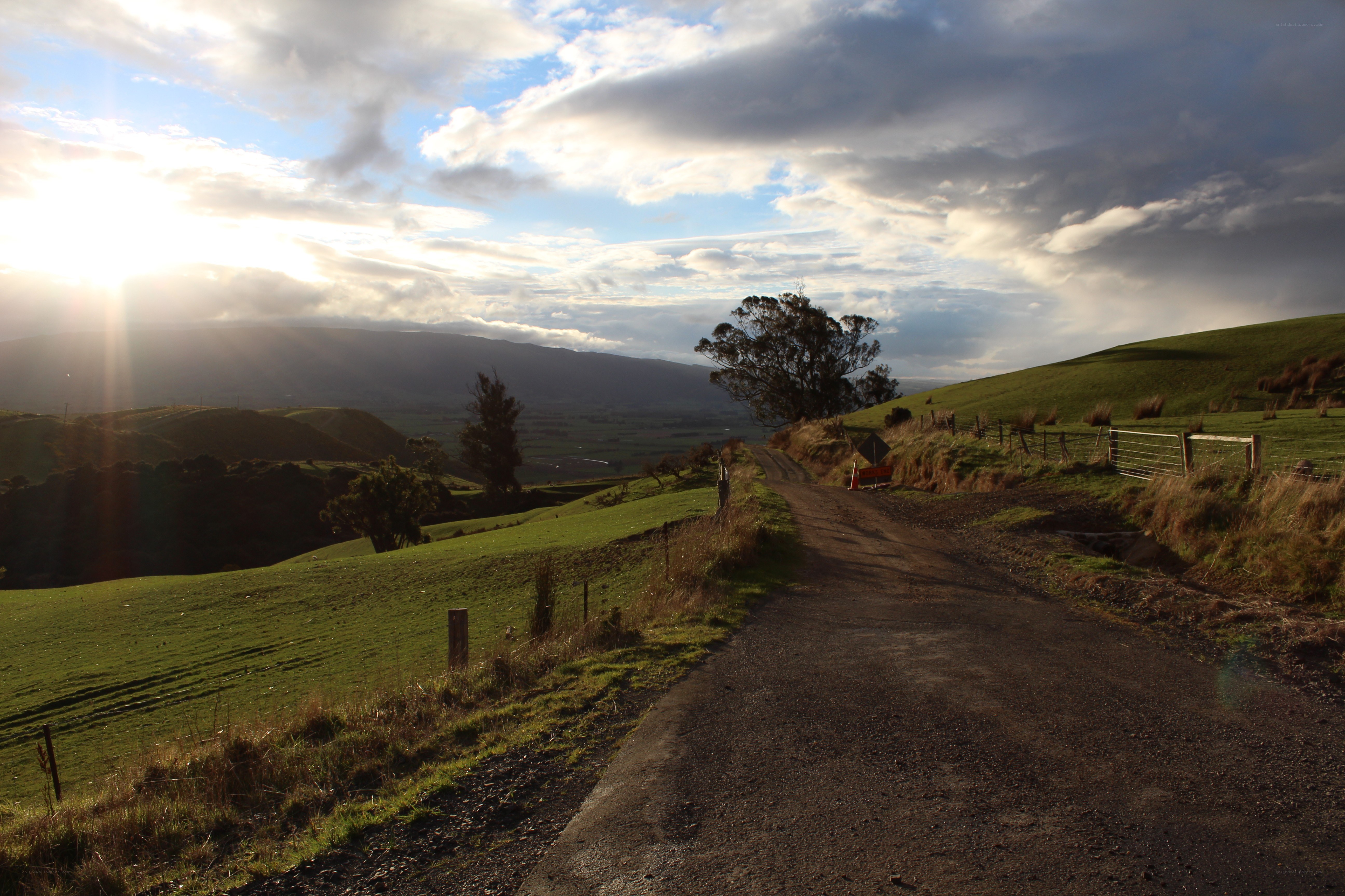 Dirt road through green hills