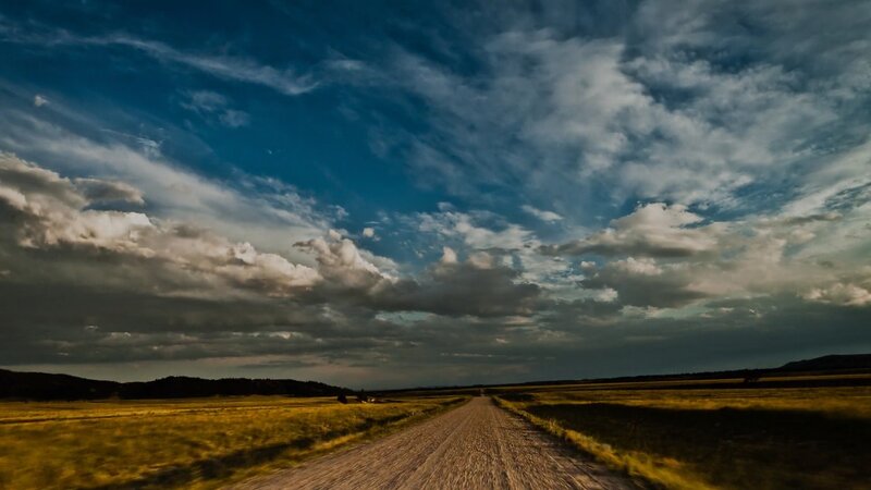 Dirt road under cloudy sky