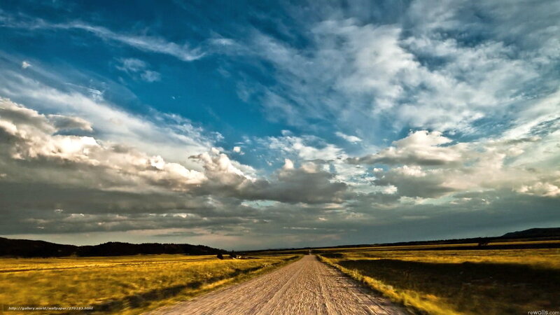 Dirt road under cloudy sky