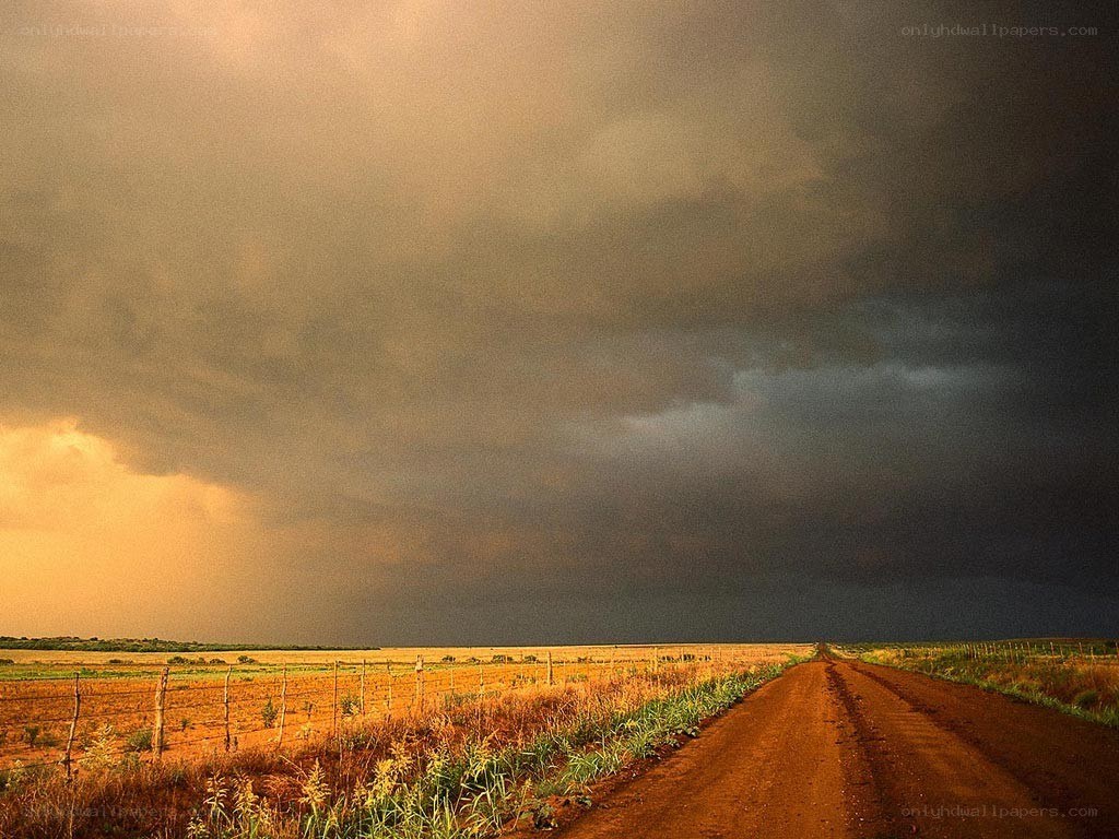 Dirt road under stormy sky