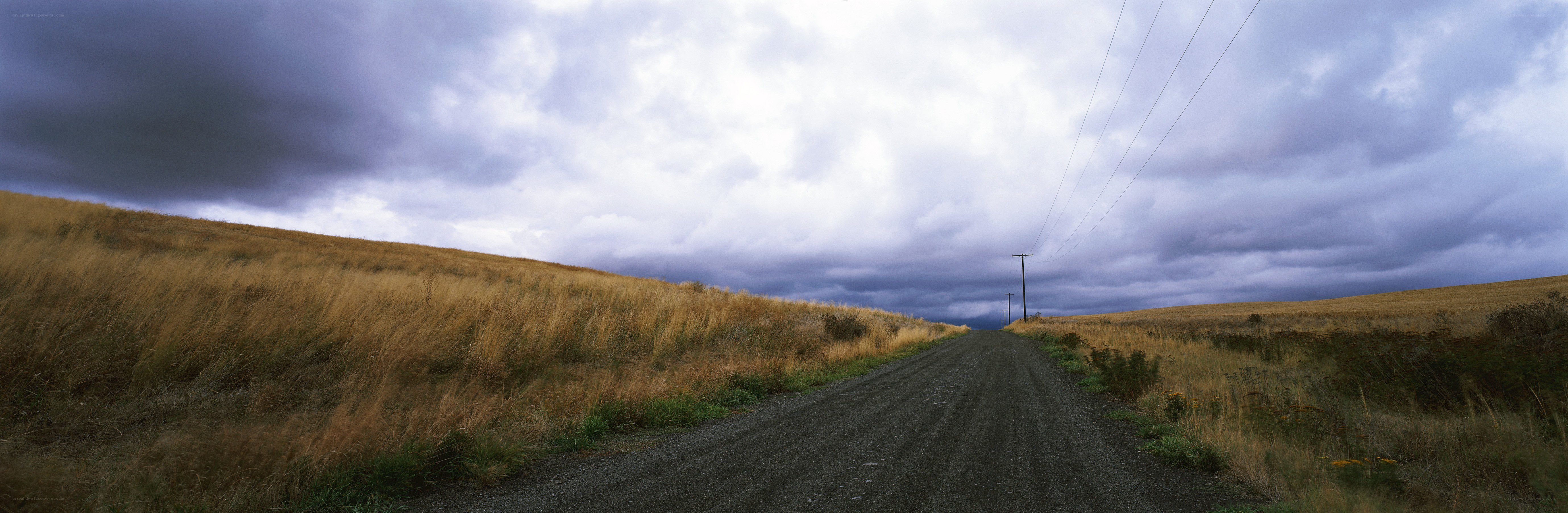 Dirt road under stormy sky