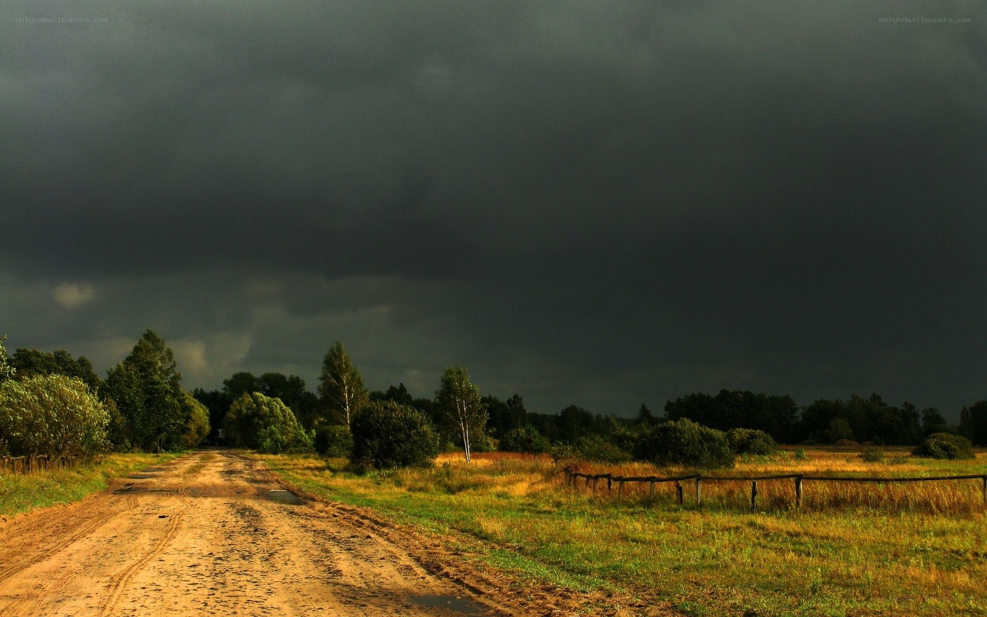 Dirt road under stormy sky