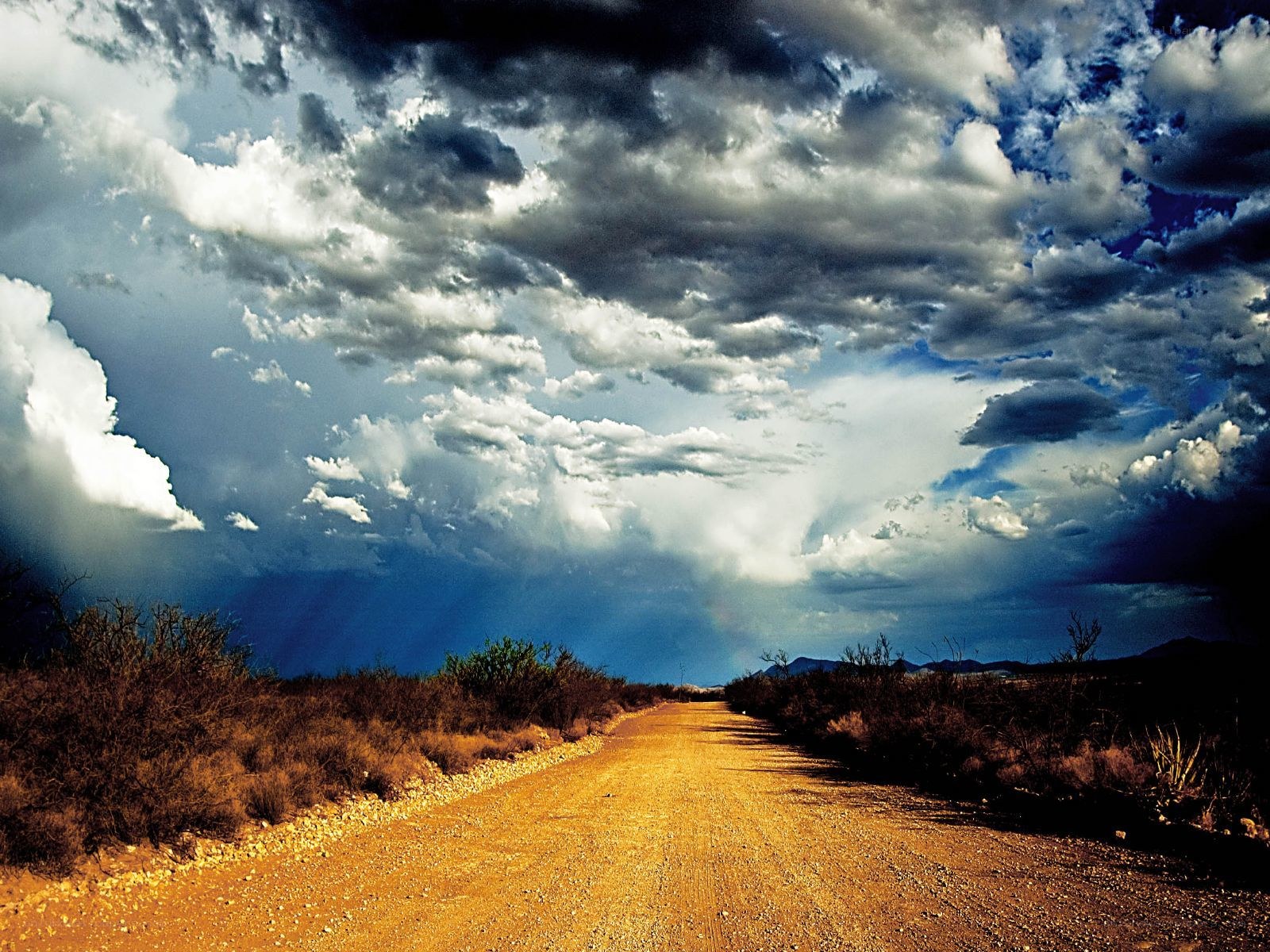 Dirt road under stormy sky