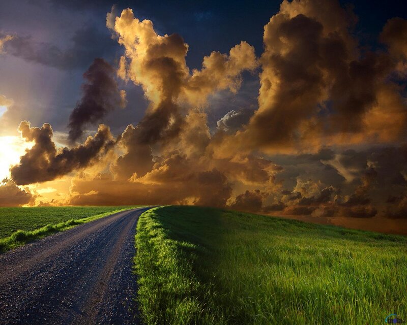Dirt road under stormy sky