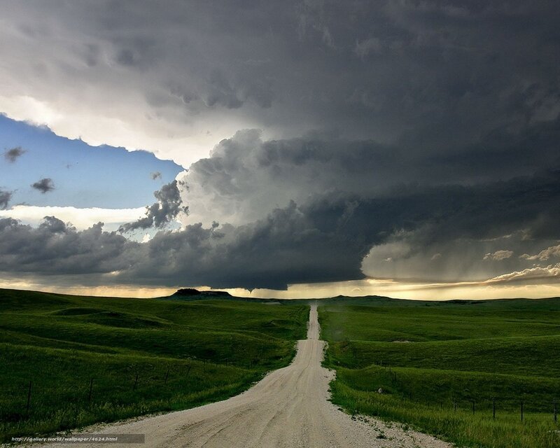 Dirt road under stormy sky