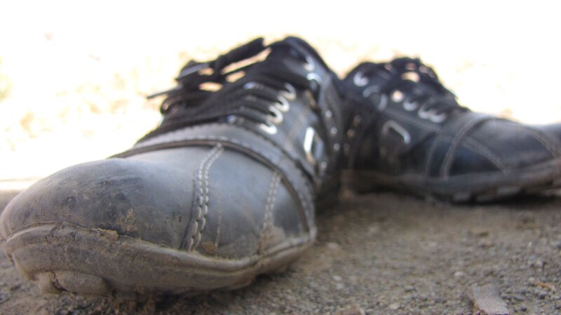 dirty black shoes on ground