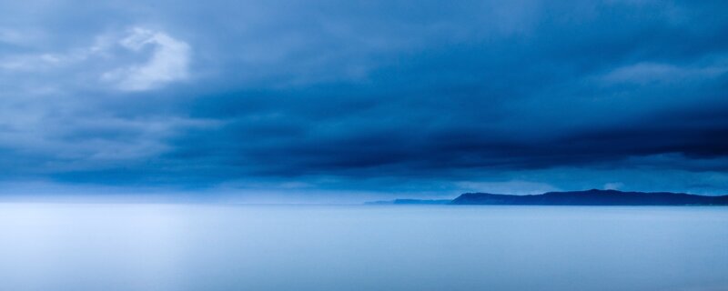 Distant Landmass under Stormy Sky