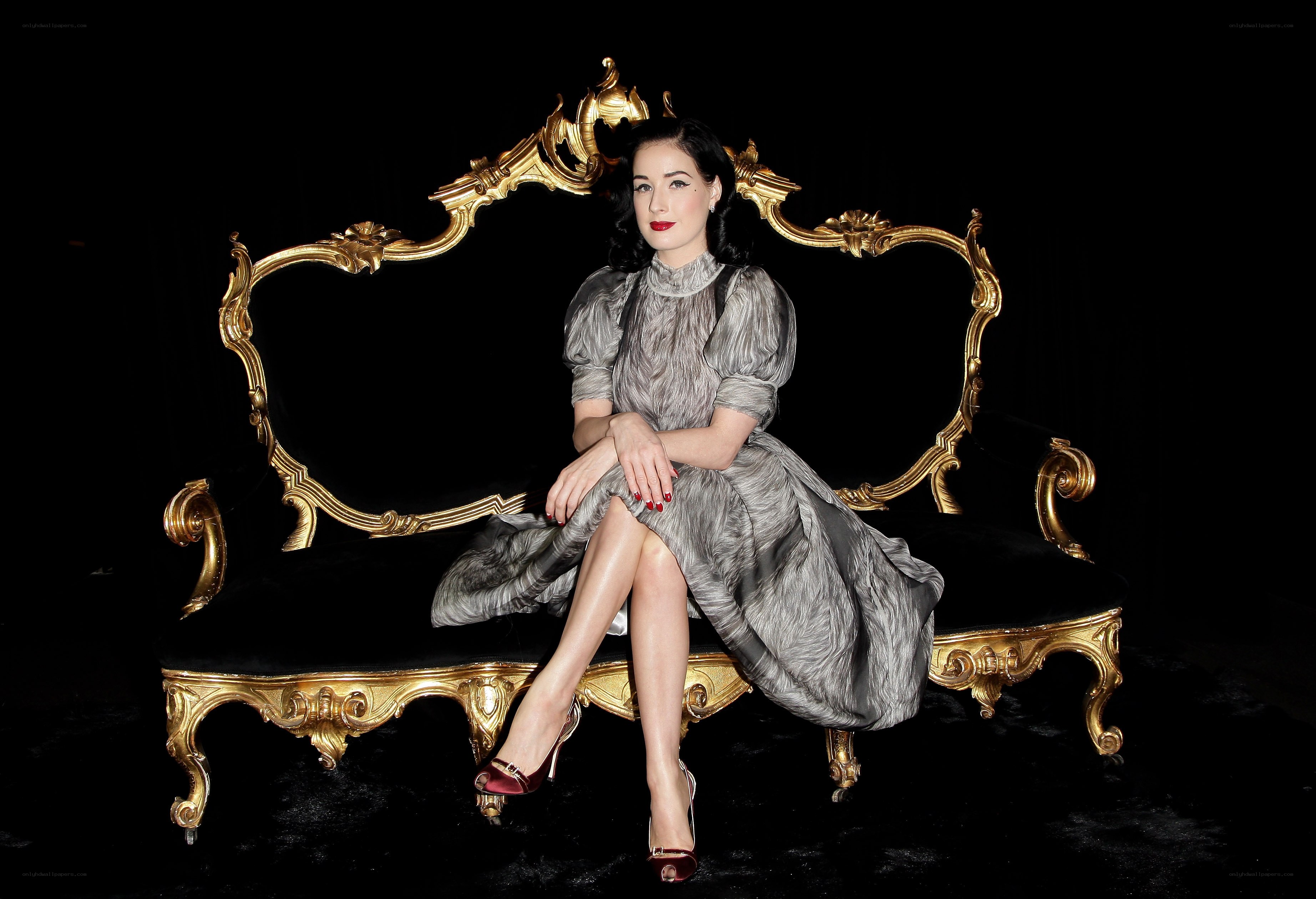 Dita Von Teese on a golden bench