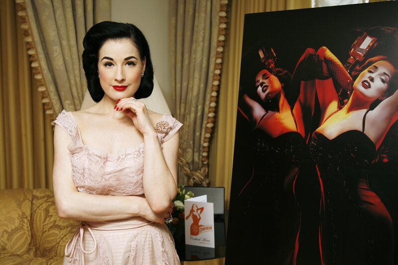 Dita Von Teese posing with poster