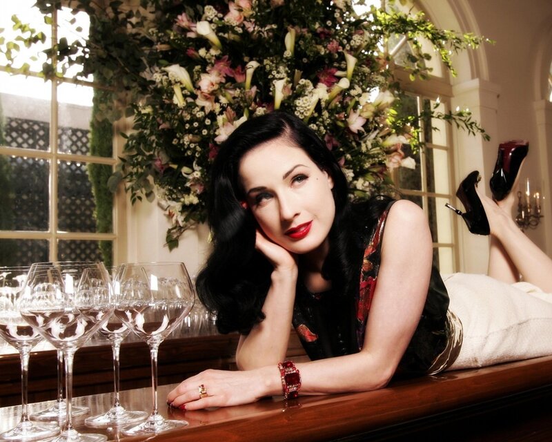 Dita Von Teese posing with wine glasses