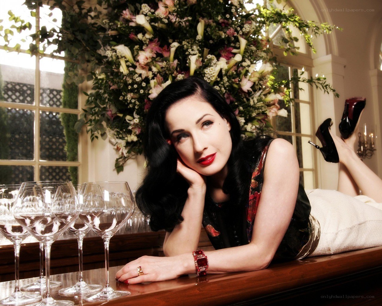 Dita Von Teese posing with wine glasses