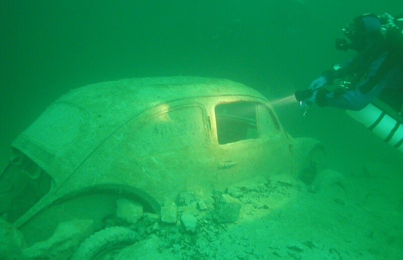 diver exploring underwater car