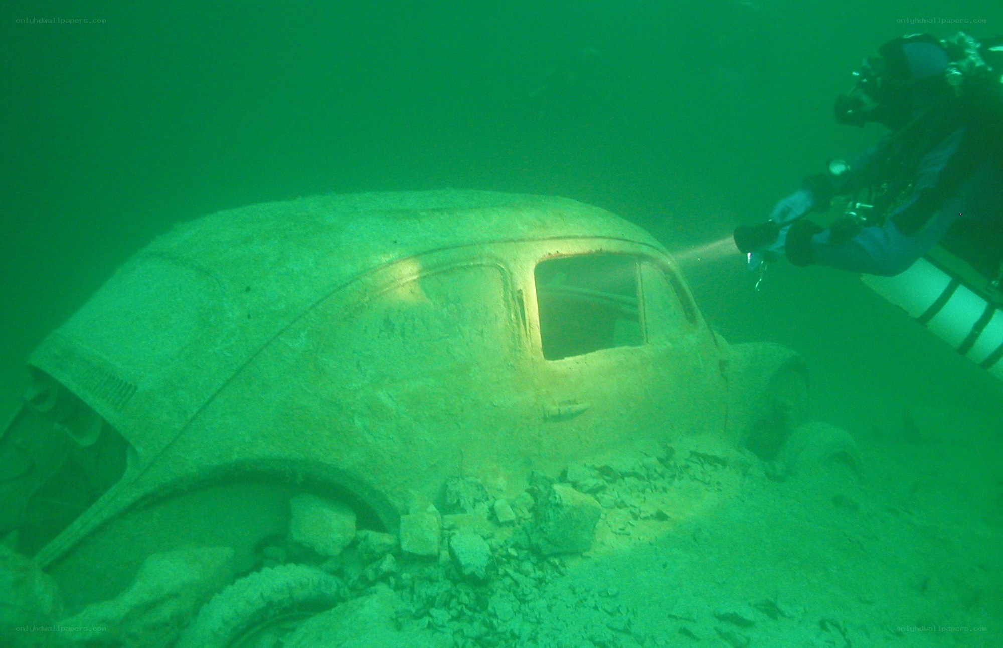 diver exploring underwater car