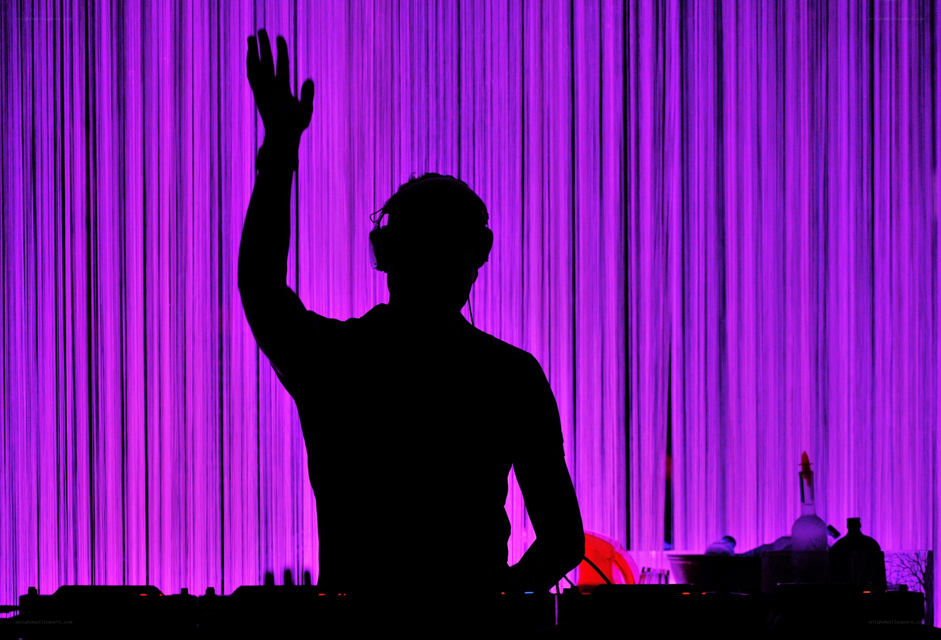 DJ silhouetted against purple lights
