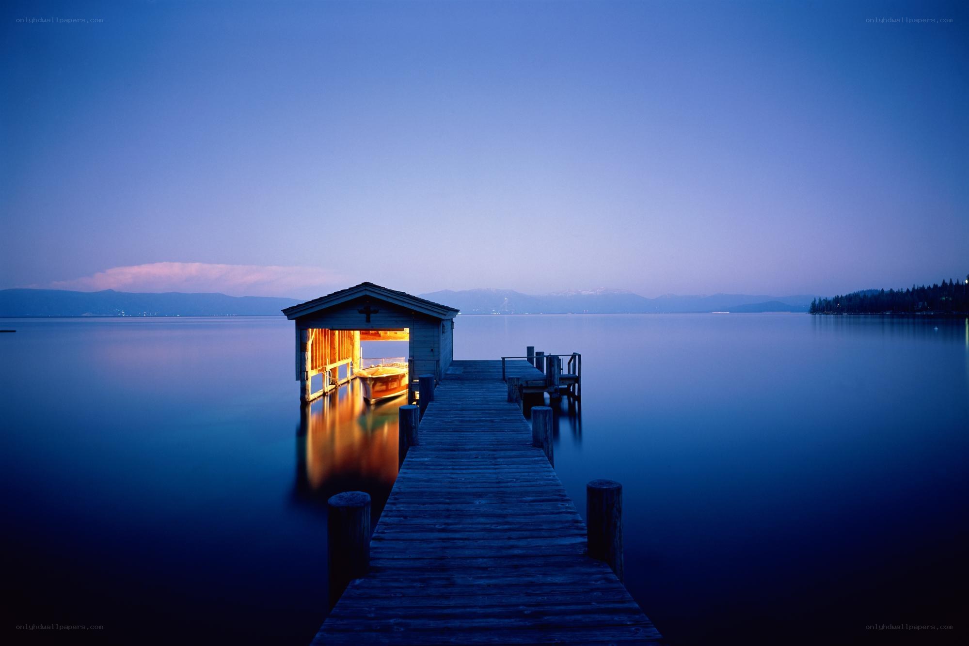 Dock at dusk with lit boathouse
