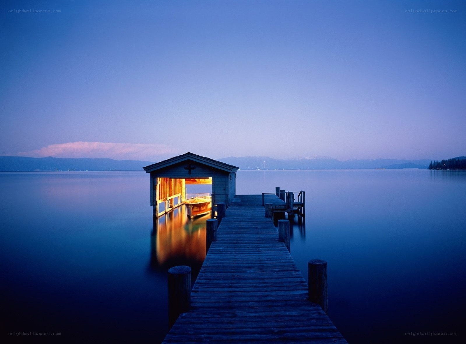 Dock at dusk with lit boathouse