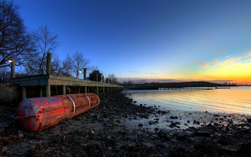 Dock at sunset with red buoy