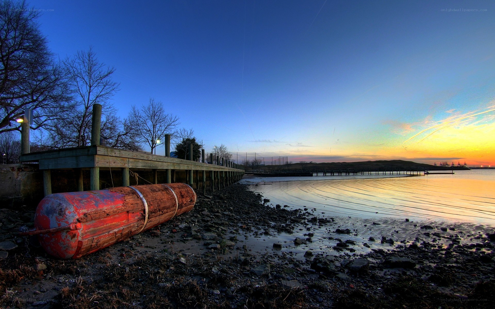 Dock at sunset with red buoy