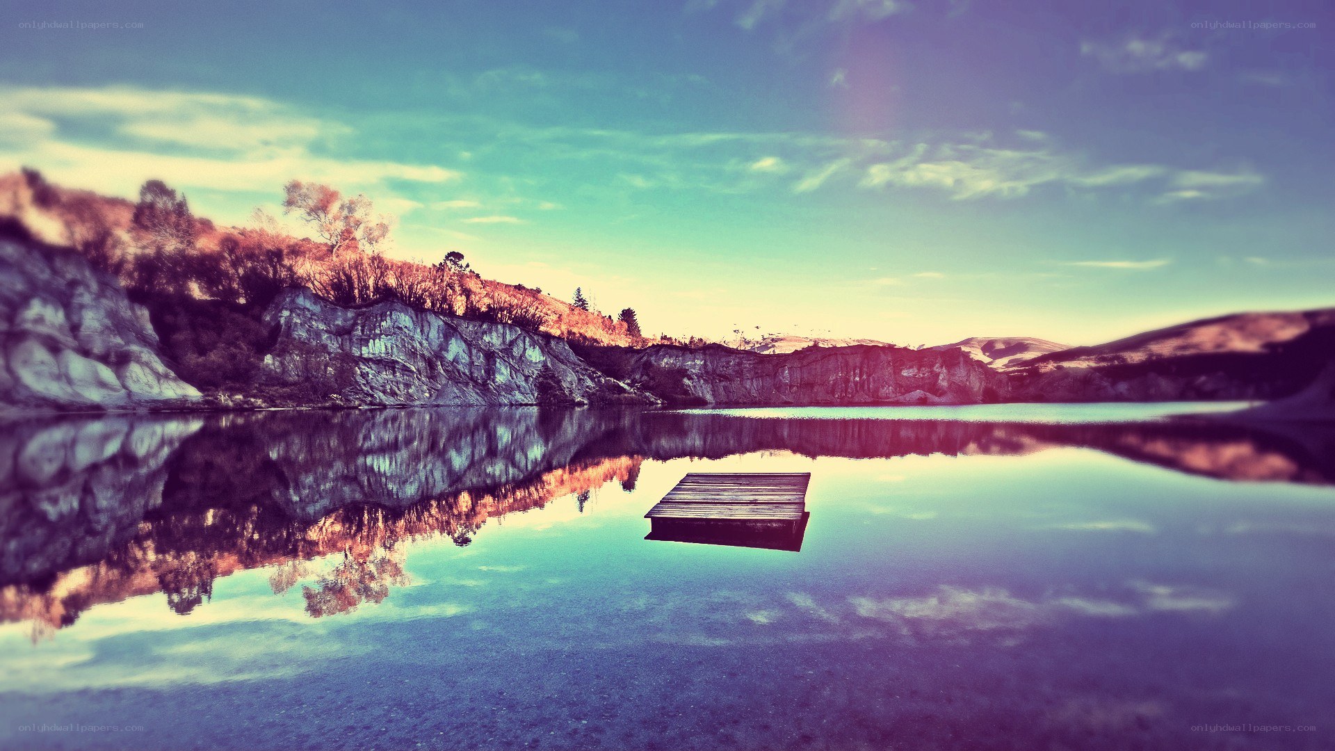 Dock on a calm lake at sunset