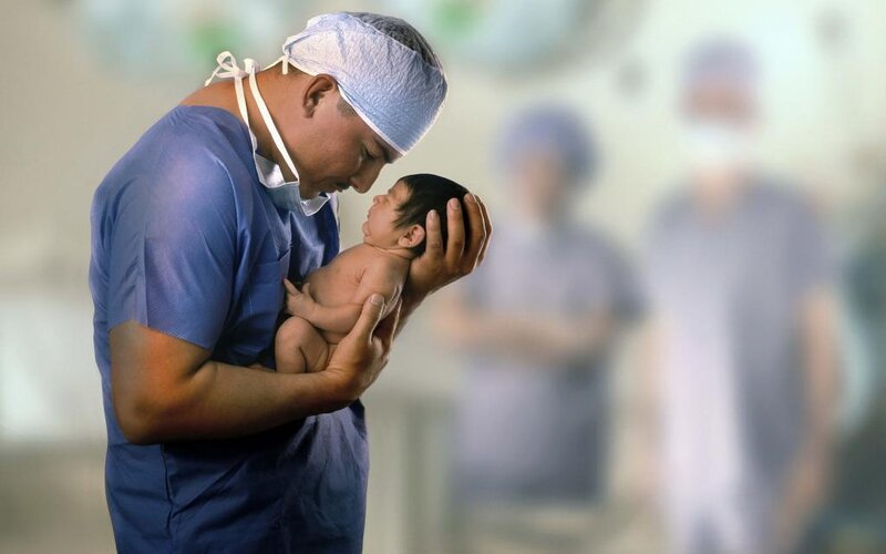 Doctor holding newborn baby