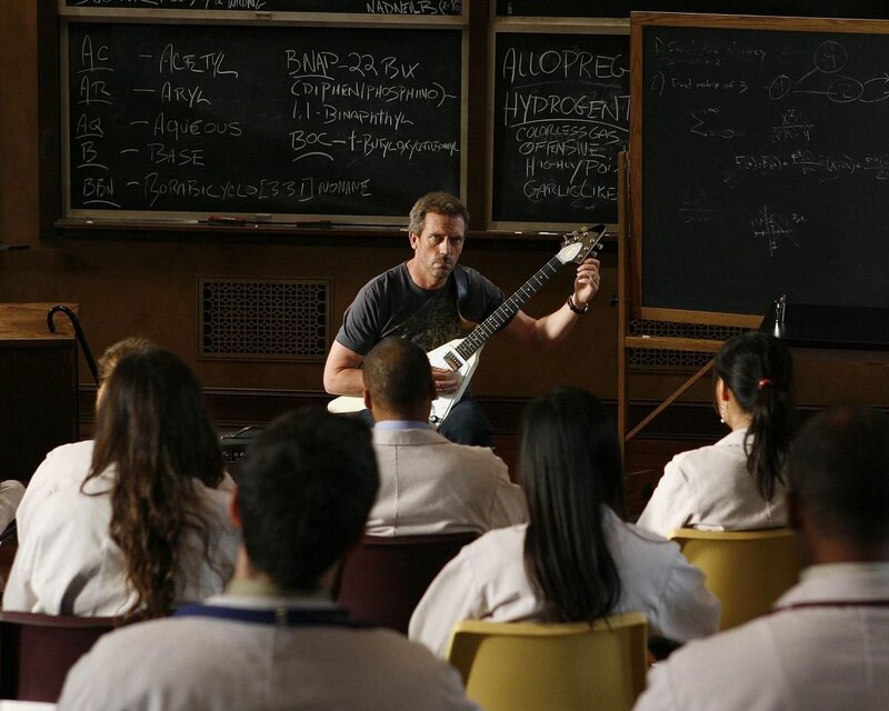 Doctor playing guitar in lecture hall
