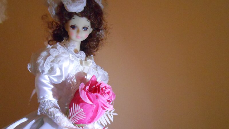 Doll Holding Pink Rose