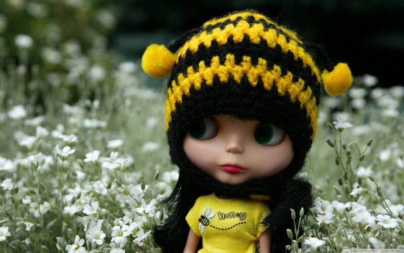 doll in bee hat among flowers
