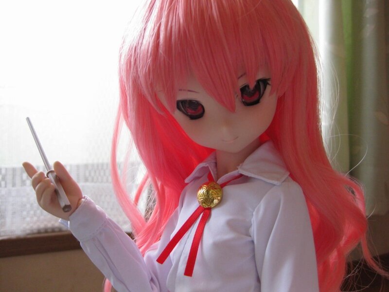 doll with pink hair holding a pen