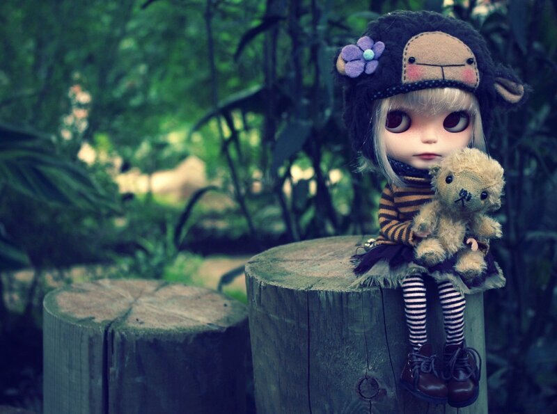 doll with teddy bear in forest