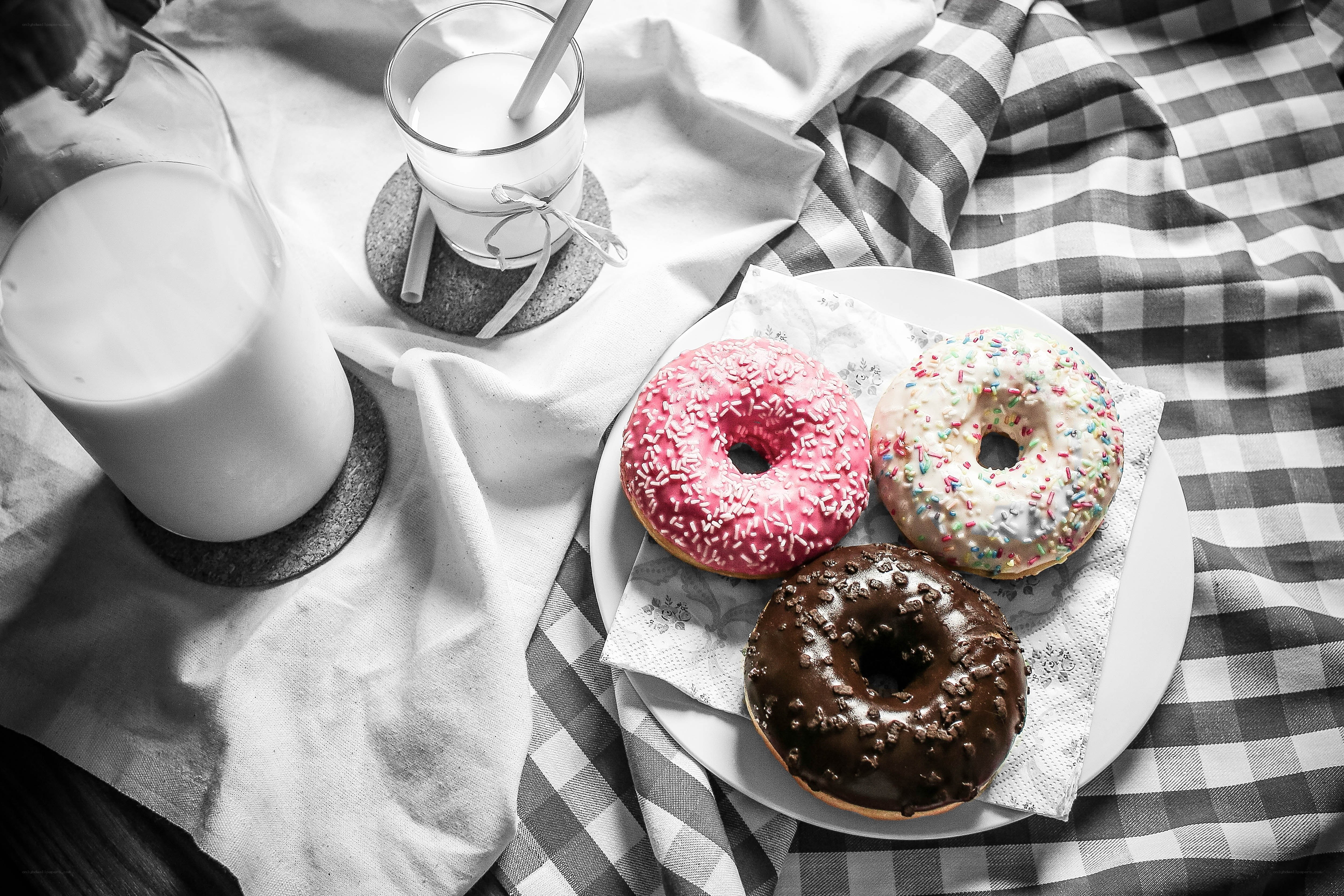 donuts and milk on checkered cloth
