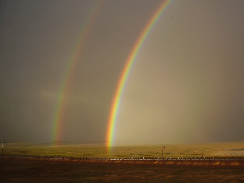 Double rainbow over a grassland