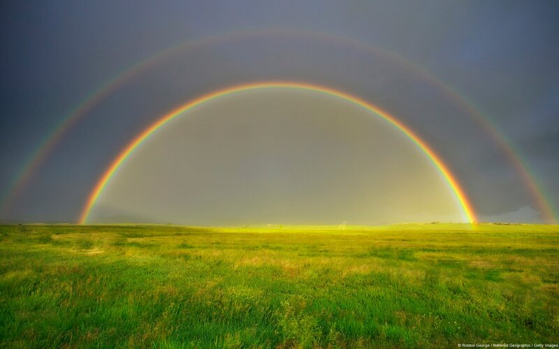 Double rainbow over a green field