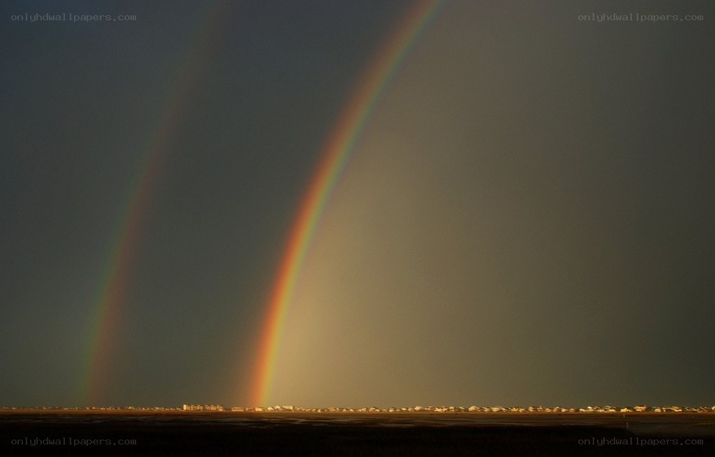 Double rainbow over coastal town