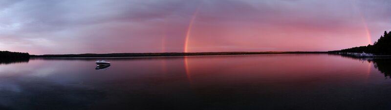 Double rainbow over lake at dusk