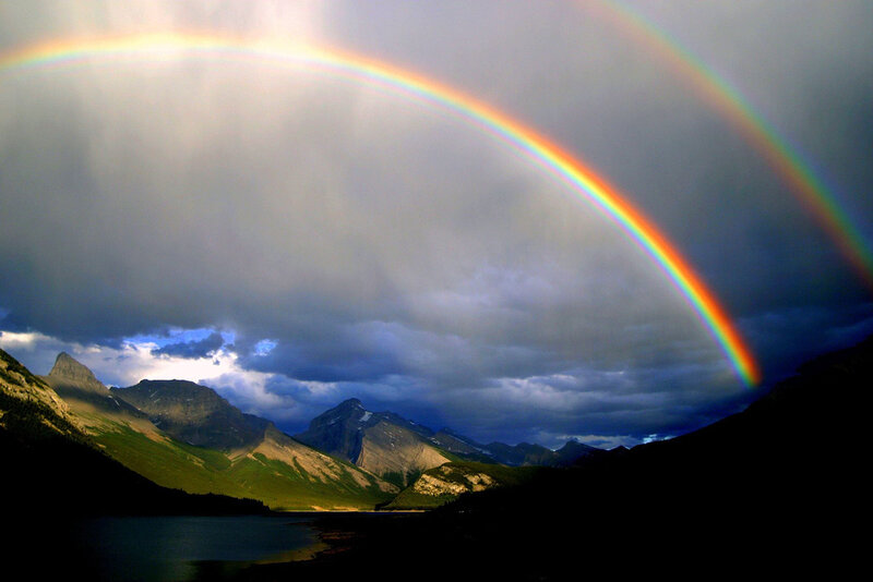 Double rainbow over mountain lake