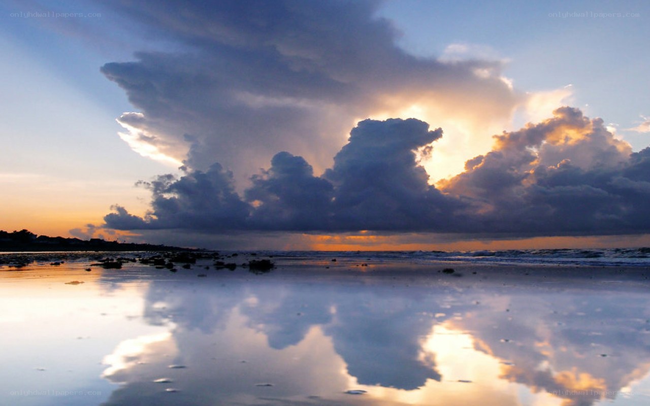 Dramatic clouds over beach at sunset