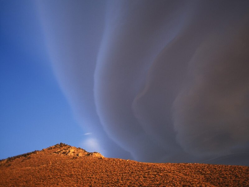 Dramatic clouds over desert hill