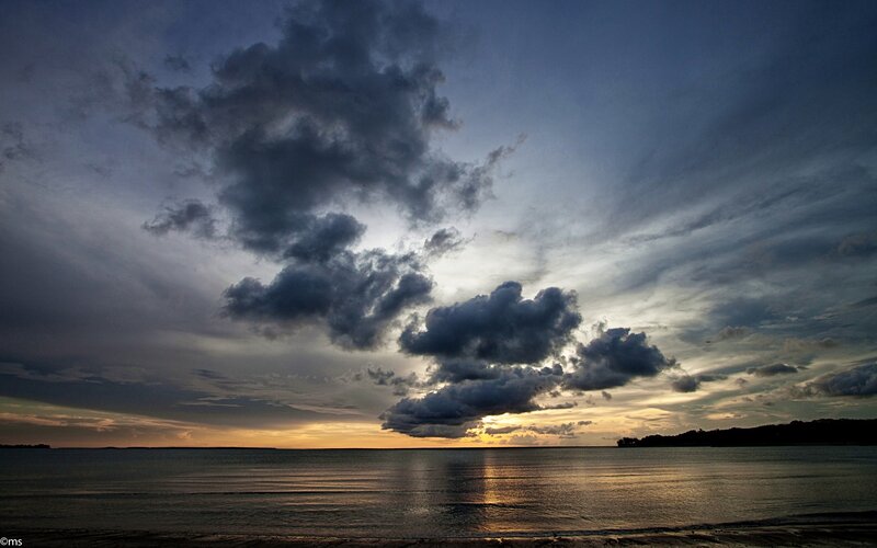 dramatic clouds over ocean at sunset