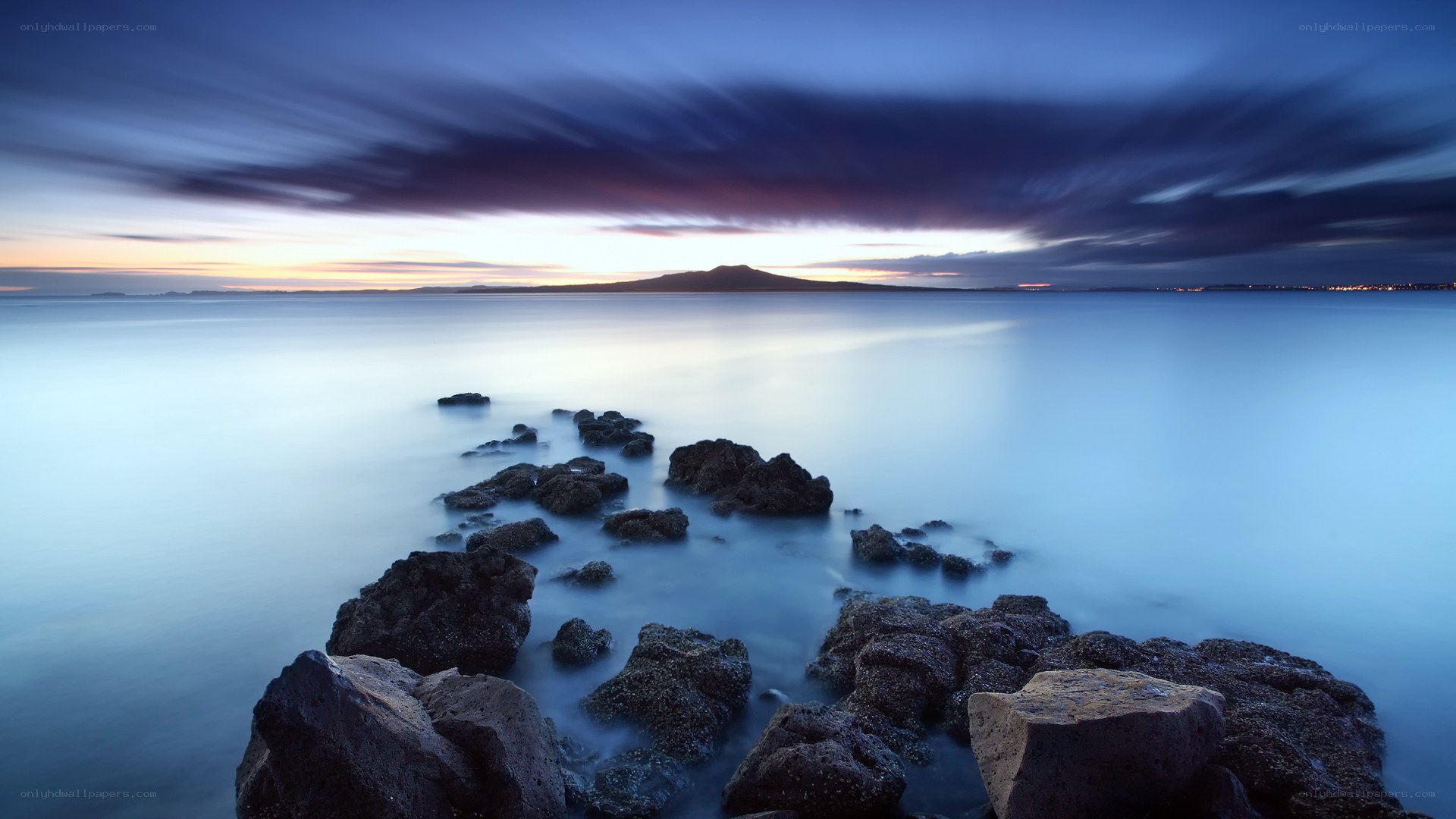 Dramatic coastal sunset with volcanic island